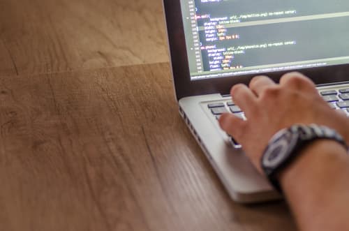 Hand on laptop keyboard