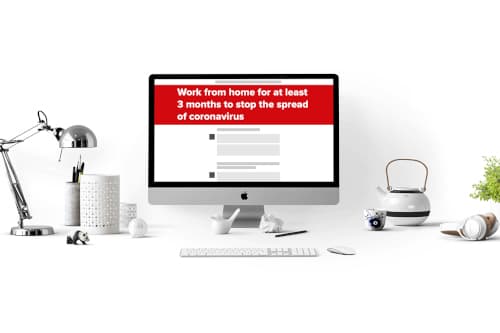 Desk with desktop computer showing a news site.